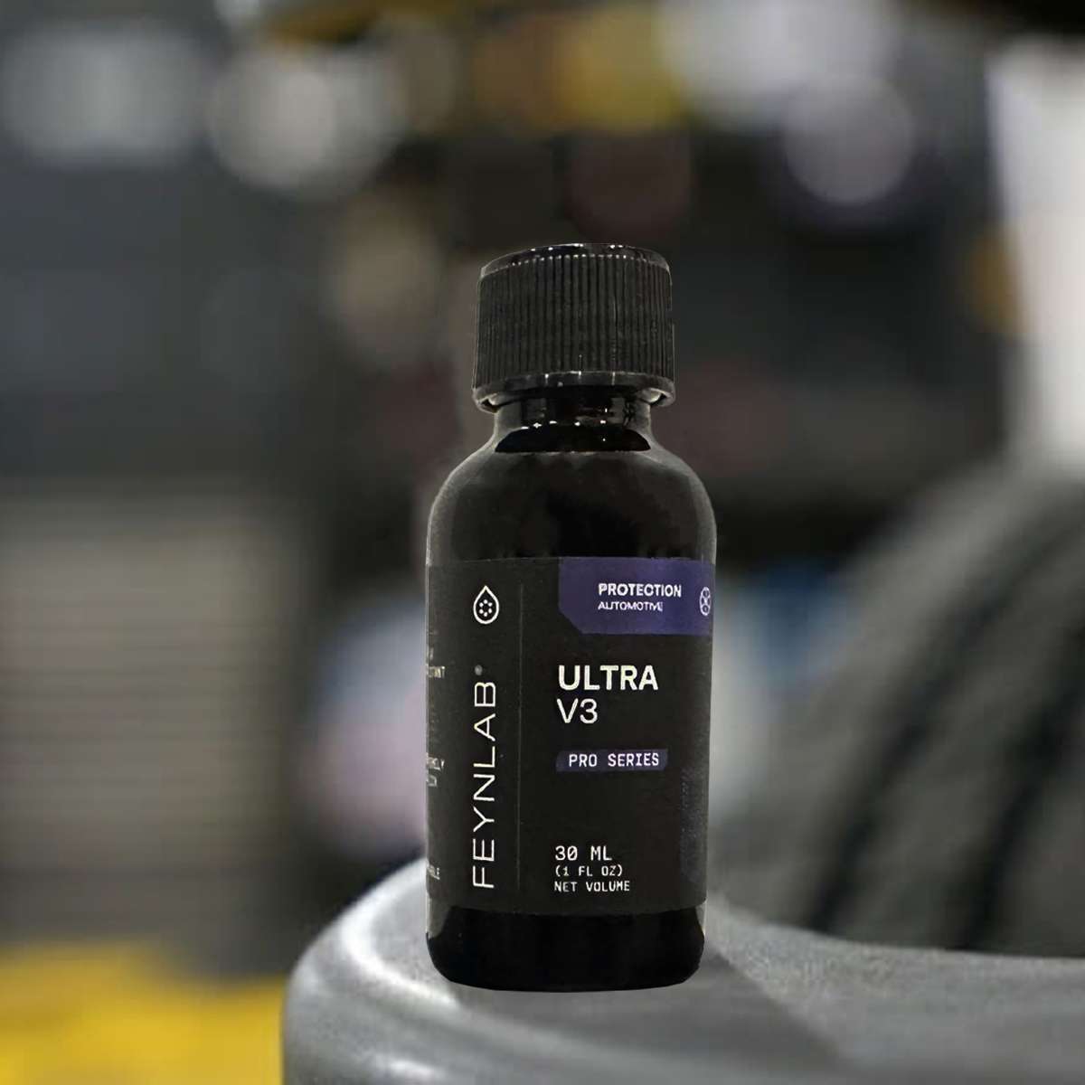 Bottle of Feynlab Ultra V3 Pro Series ceramic coating resting on a tyre