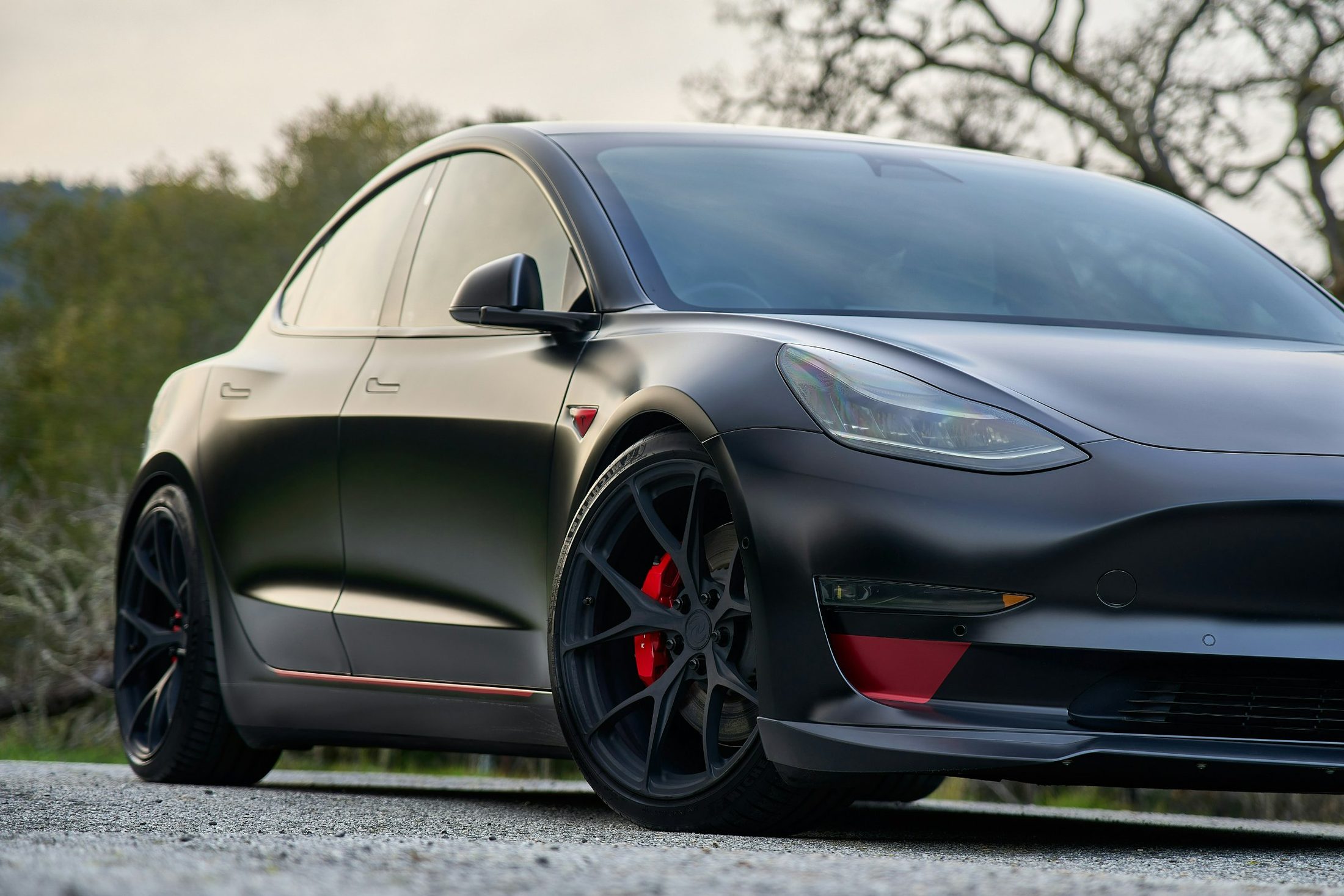 Satin black Tesla Model 3, front three-quarter view